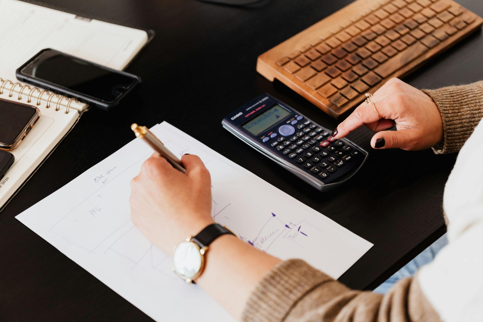 Un homme d'affaires organise ses finances avec des appareils technologiques et de l'argent liquide sur son bureau.