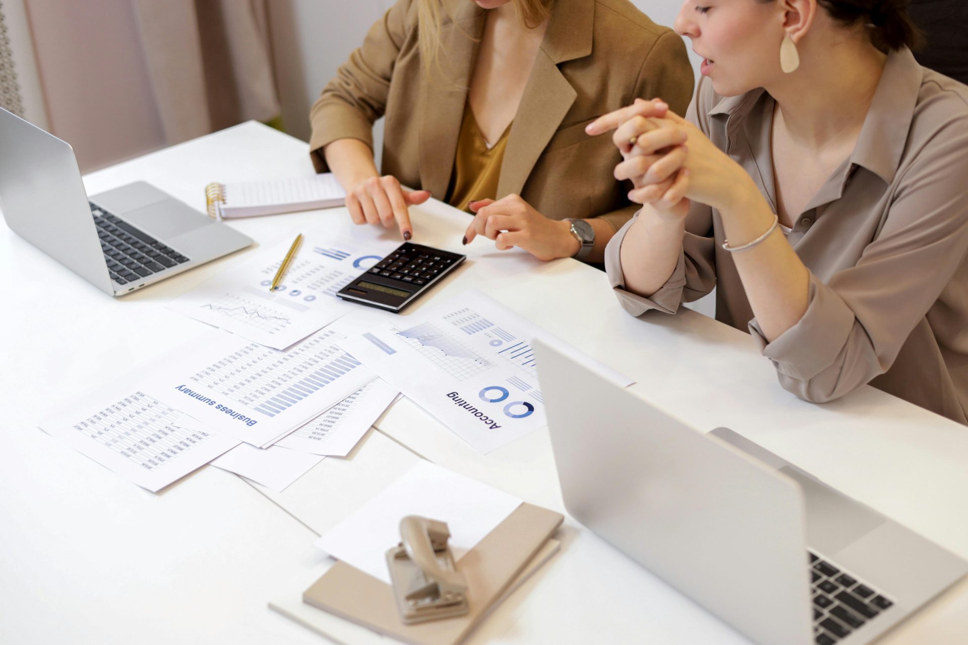 Deux professionnels collaborant sur des documents financiers dans un environnement de bureau moderne.