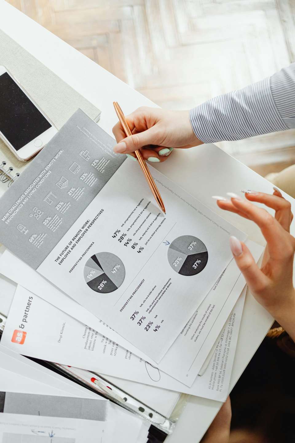 Gros plan d'une femme d'affaires analysant des rapports financiers à l'aide de graphiques à secteurs dans un bureau.